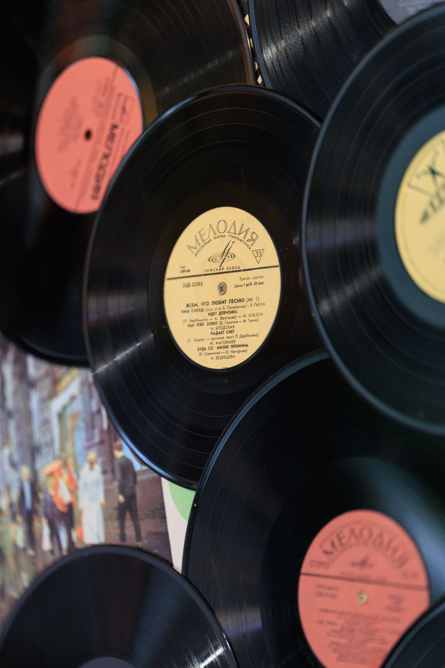 Vintage vinyl records with colorful labels showcased in an artistic display on a wall.