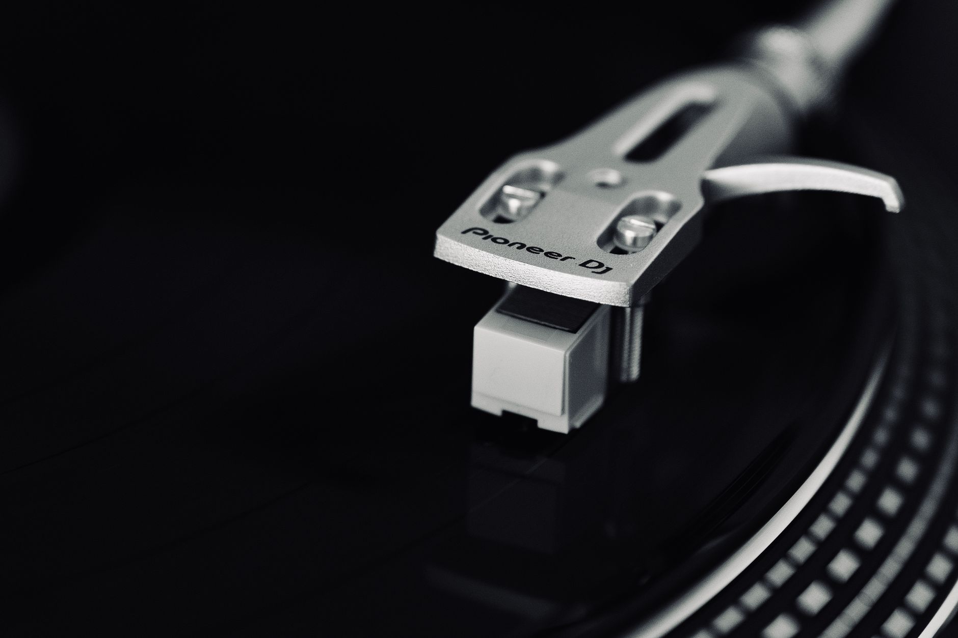 Detailed view of a Pioneer DJ turntable needle emphasizing music technology and nostalgia.