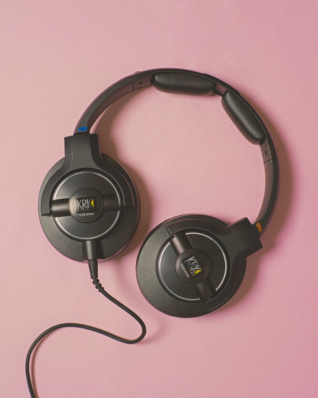 Close-up of KRK headphones on a pink background, perfect for music and audio technology themes.